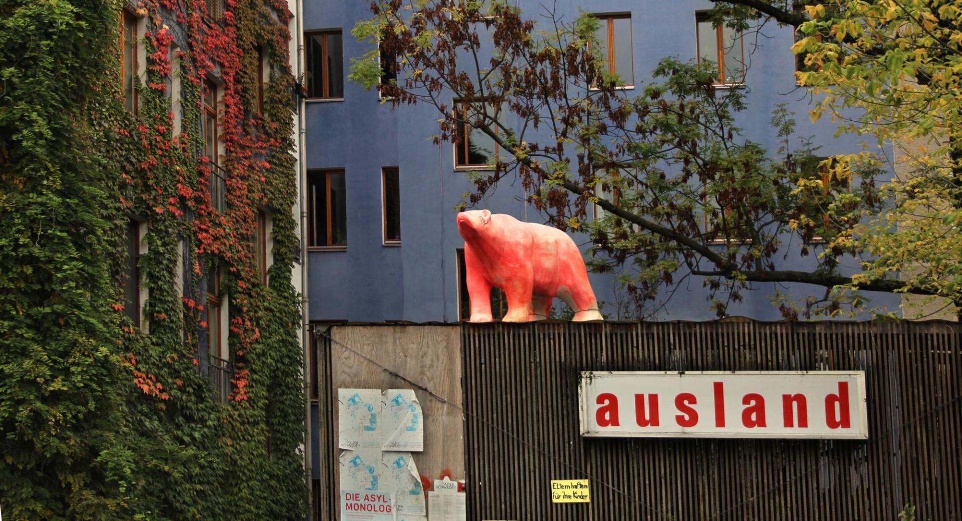 eine rosafarbene Eisbärenstatue steht auf einem Gebäude mit der Aufschrift &quot;ausland&quot;.