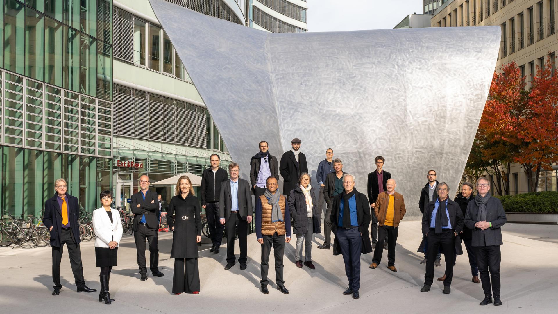 The orchestra in front of a steel sculpture